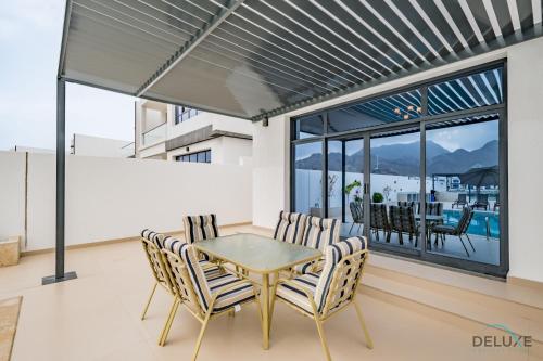 a dining room with a table and chairs at Deal of the Week 4BR with Pool, Sea & Mountain Views by Deluxe Holiday Homes in Sharm