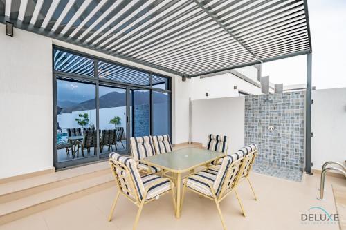 a dining room with a table and chairs at Deal of the Week 4BR with Pool, Sea & Mountain Views by Deluxe Holiday Homes in Sharm