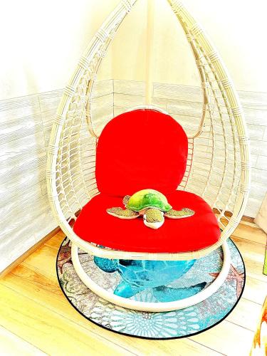 a red chair with a turtle sitting on it at ほんだけ in Ishigaki Island