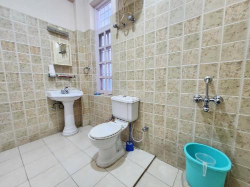 a bathroom with a toilet and a sink at Rashmi Cottage - 4 BHK Villa with Serene Valley Views in Dagshai