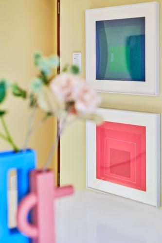 a vase with pink flowers in front of a tv at 寅ホテル 御徒町 TORA HOTEL Okachimachi in Tokyo