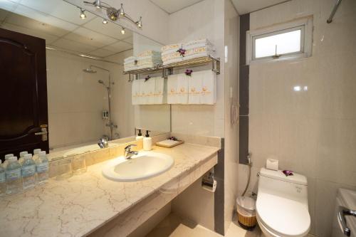 a bathroom with a sink and a toilet and a mirror at Cap Town Hotel in Ho Chi Minh City