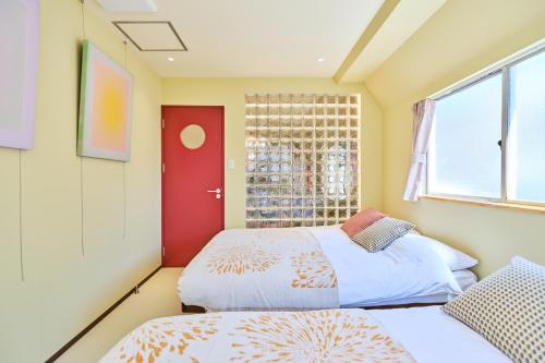 two beds in a room with a window at 寅ホテル 御徒町 TORA HOTEL Okachimachi in Tokyo
