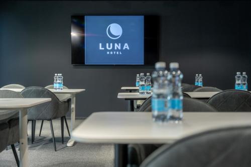 a room with tables and chairs with water bottles on them at Luna Self Check-in Hotel Klaipeda in Klaipėda