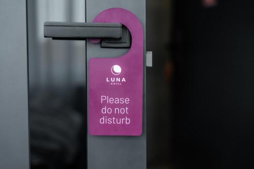 a sign that says please do not disturb on a door at Luna Self Check-in Hotel Klaipeda in Klaipėda