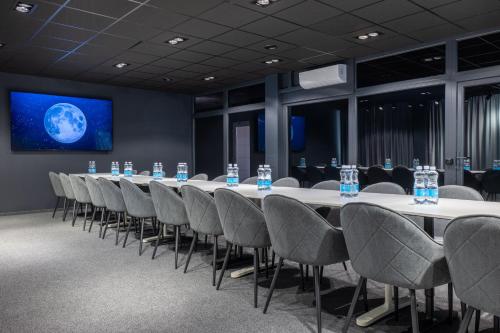 a conference room with a long table and chairs at Luna Self Check-in Hotel Klaipeda in Klaipėda