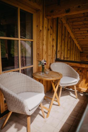 two chairs and a table on a porch at Salzbergalm in Berchtesgaden