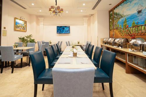 a dining room with a long table and blue chairs at Cap Town Hotel in Ho Chi Minh City