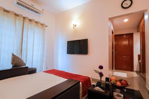 a bedroom with a bed and a television on the wall at MGM Vailankanni in Velānganni