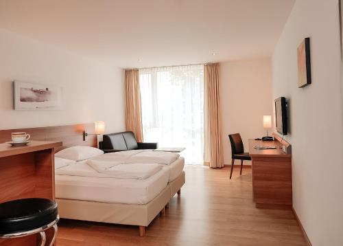 a living room with a white couch and a table at Fairmotel Dornbirn in Dornbirn
