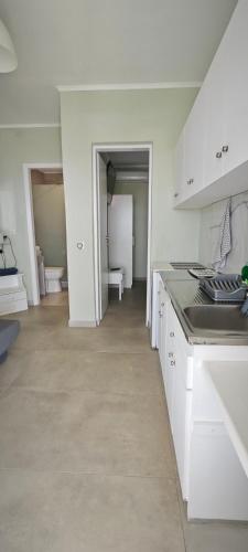 a kitchen with white cabinets and a counter top at Garlis Apartments in Psakoudia