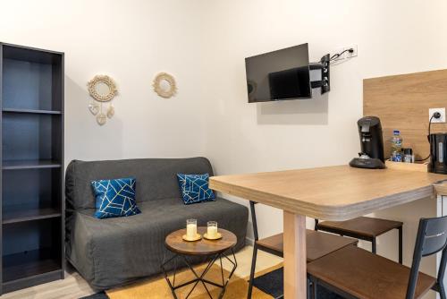 un salon avec un canapé et une table dans l'établissement Studio 25m2 rénové, tout confort, à Le Petit-Quevilly