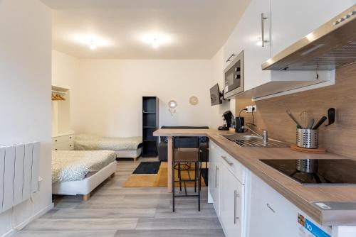 une cuisine avec des armoires blanches et un comptoir dans l'établissement Studio 25m2 rénové, tout confort, à Le Petit-Quevilly