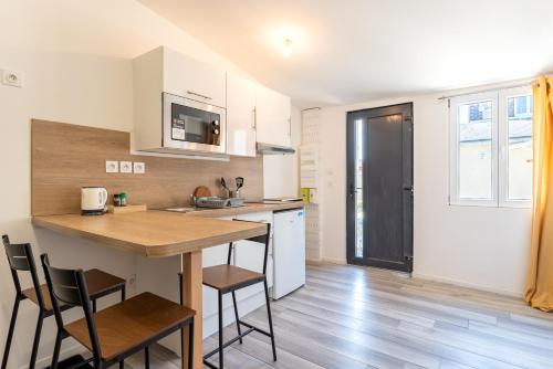 une cuisine avec une table et des chaises dans une pièce dans l'établissement Studio 25m2 rénové, tout confort, à Le Petit-Quevilly