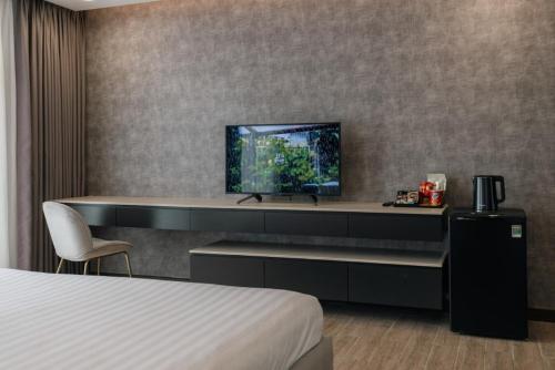 a hotel room with a bed and a flat screen tv at Luxhome Mekong Hotel in Can Tho