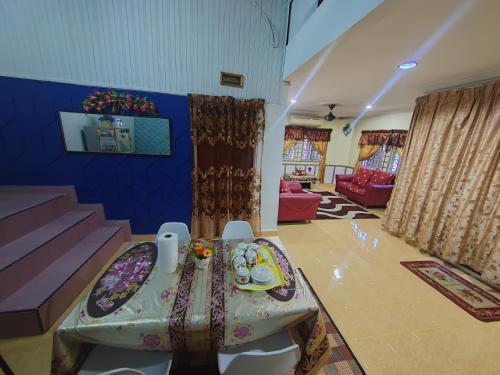 a living room with a table in the middle at Iltizam Homestay in Kuala Berang