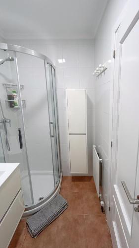 un bagno bianco con doccia e lavandino di Comillas - Urbanización Lagos Azules - Netflix, Prime, Wifi & Free Indoor Parking a Casasola