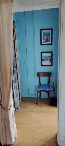 une chambre bleue avec une chaise et une fenêtre dans l'établissement Jardin SAY, à Nantes