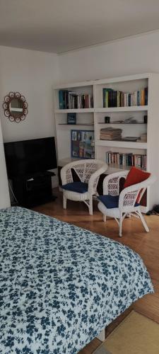 un salon avec deux lits, une télévision et des étagères dans l'établissement Jardin SAY, à Nantes