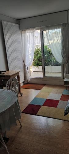 un salon avec une table et une grande fenêtre dans l'établissement Jardin SAY, à Nantes