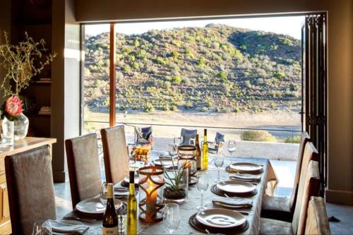 a table with plates and glasses on it with a view at Karoo62 Luxury Lodge in Ladismith