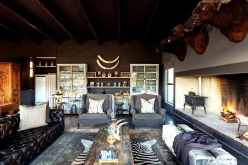 a living room with couches and a fireplace at Karoo62 Luxury Lodge in Ladismith