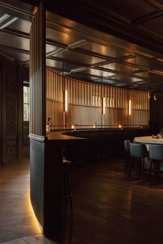 a restaurant with a bar with tables and chairs at Spa & Resort Bachmair Weissach, LUXURY FAMILY RESORT in Rottach-Egern
