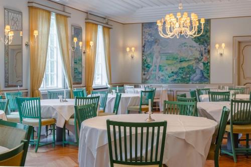 a dining room with tables and chairs and a chandelier at Orkla Gjestebolig in Løkken