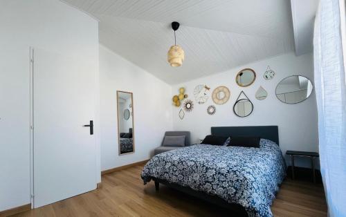 une chambre avec un lit et des miroirs au mur dans l'établissement Pinède, plage et billard, à La Rudelière