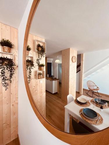 - un miroir circulaire dans le salon avec une table et des chaises dans l'établissement Pinède, plage et billard, à La Rudelière