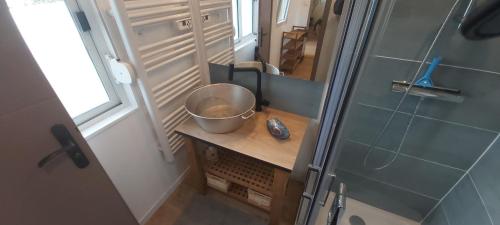 - une petite salle de bains avec un bol sur une table en bois dans l'établissement Cabane en bois au calme, à Saint-Romain-de-Benet