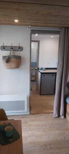 un salon avec une table et une cuisine dans l'établissement Cabane en bois au calme, à Saint-Romain-de-Benet