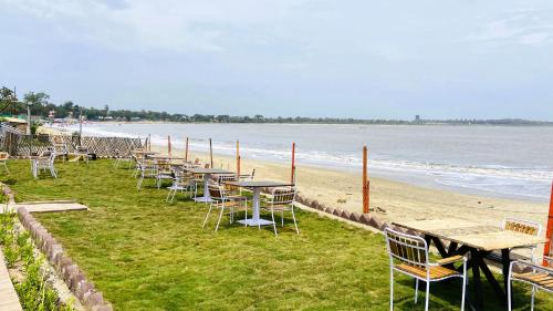 a row of tables and chairs on the beach at Kamnath Zinc Journey by The Fern, Diu in Diu