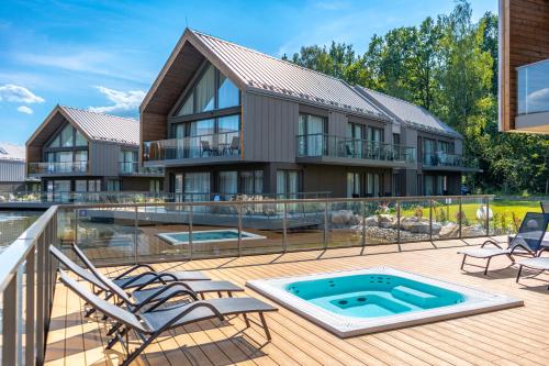 a house with a swimming pool and a deck with chairs at Termy Karkonosze Resort & Spa koło Karpacza in Staniszów