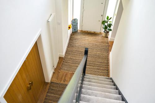 a staircase in a hallway with a door at Chic Family Home with Garden Fire Pit & Event Space, Hot Tub in Manchester