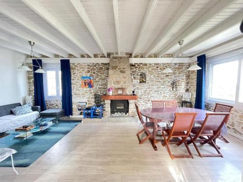 un salon avec une table et une cheminée dans l'établissement Jolie maison avec vue mer imprenable proche plage, à Plouguerneau