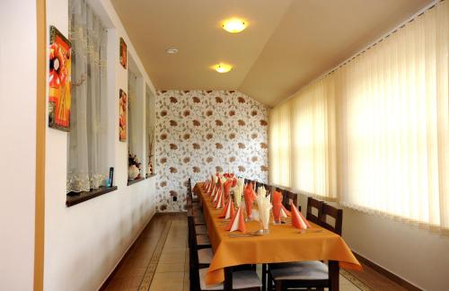a dining room with a long table with orange chairs at Penzión ZIVKA in Závažná Poruba
