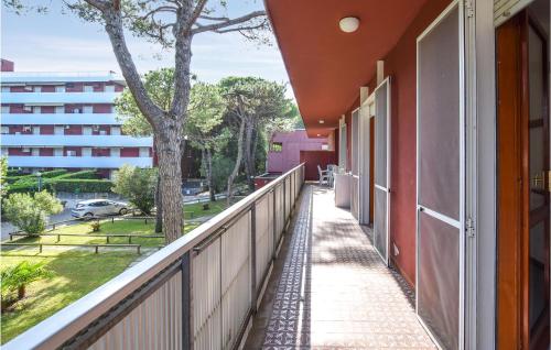 a balcony with a tree and a building at Amazing Apartment In Lignano Sabbiadoro in Lignano Sabbiadoro