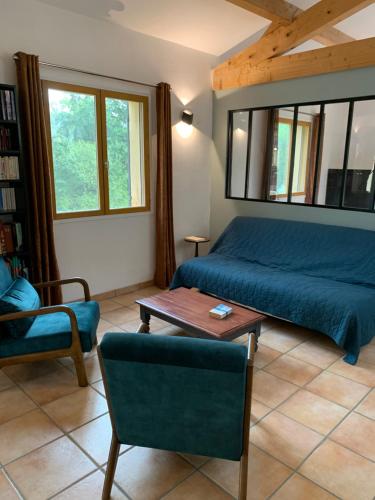 une chambre avec un lit, une table et une chaise dans l'établissement Maison du vallon de Galeye, à La Roque-sur-Pernes