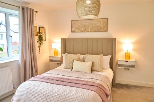 a bedroom with a bed with two lamps and a window at Chic Family Home with Garden Fire Pit & Event Space, Hot Tub in Manchester