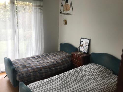 una camera con due letti, un comò e una finestra di Maison de vacances à Saint Quay Portrieux a Saint-Quay-Portrieux