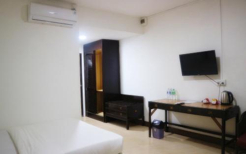 a room with a desk and a tv on a wall at Hotel Riau Holidays in Tanjung Pinang 