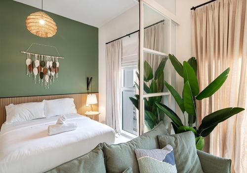 a bedroom with a bed and a potted plant at First Class Apartments in Dubai Hills - Next to Dubai Hills Mall - Socio, Collective and Golfville Towers in Dubai