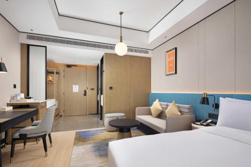 a hotel room with a bed and a living room at Hilton Garden Inn Chengdu Chenghua in Chengdu