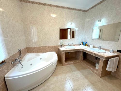a large bathroom with two sinks and a tub and a tub at Rosa's House - zona ospedaliera in Cagliari
