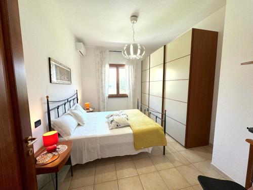 a bedroom with a bed and a table and a chandelier at Rosa's House - zona ospedaliera in Cagliari
