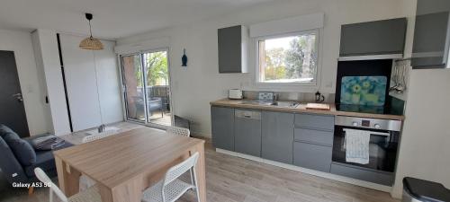 une cuisine avec une table en bois et une salle à manger dans l'établissement Ma Mika - Appartement proche mer, à Saint-Nazaire