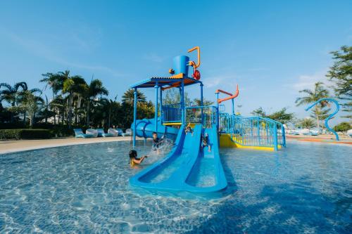 two children playing on a water slide in a swimming pool at Solea Mactan Resort in Mactan