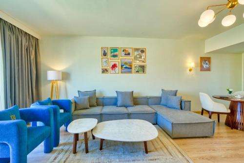 a living room with a blue couch and chairs at LOFTS by Elegant Hospitality in Cairo