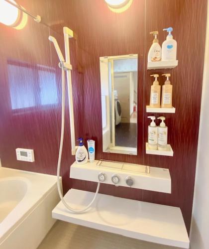 a bathroom with a shower and a sink and a mirror at U&T House in Beppu